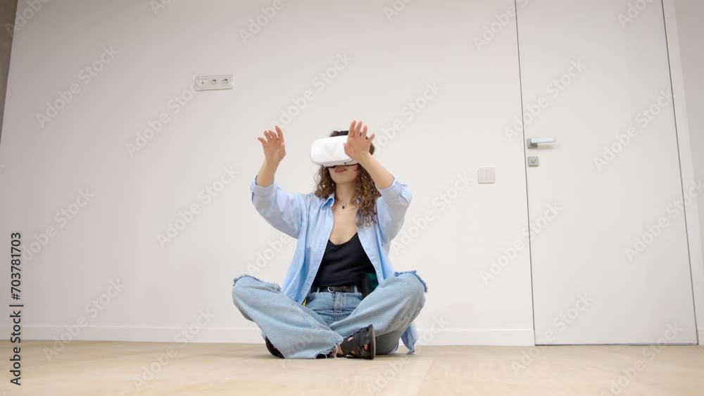 A teenage girl in virtual reality glasses or 3D glasses sits in a room. People entertainment concept. Technology, virtual reality, cyberspace A teenage girl in virtual reality glasses or 3D glasses sits in a room. People entertainment concept. Technology, virtual reality, cyberspace