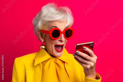 Colorful studio portrait of an old woman using modern day technology and gadgets. Bold, vibrant and minimalist. Generative AI © Mihai Zaharia