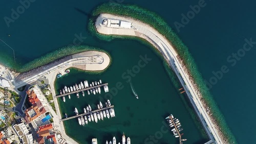Aerial view of Lustica Bay, Adriatic sea, Montenegro. Top view of buildings, Harbor Marina with moored boats and yachts and lighthouse against the backdrop of mountains. New modern luxury resort. photo