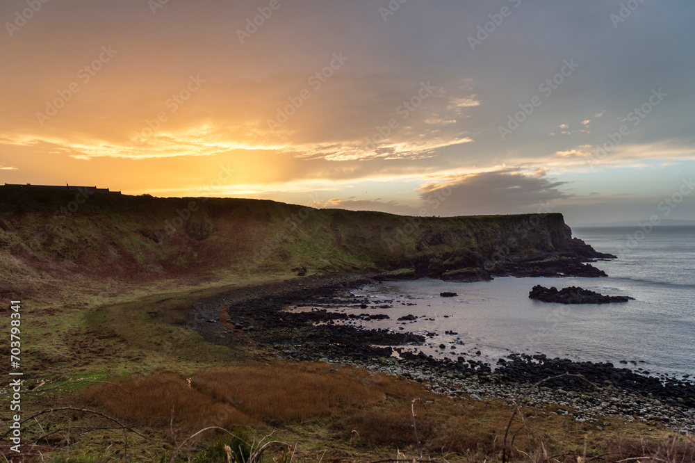 imagen de la playa de la Calzada del Gigante en Irlanda del norte con la puesta de sol de fondo