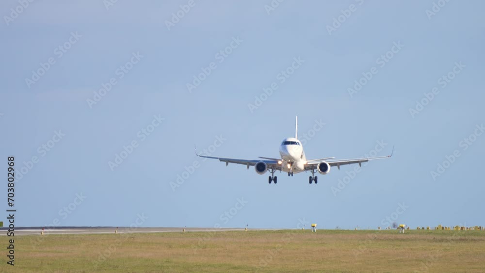 Passenger plane fly down on runway. Airplane approaching and landing at early morning. Slow motion shot of landing jet liner. Small jet aircraft arriving at international airport on summer day Passenger plane fly down on runway. Airplane approaching and landing at early morning. Slow motion shot of landing jet liner. Small jet aircraft arriving at international airport on summer day