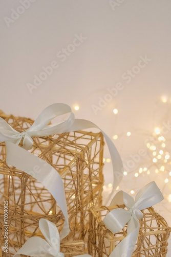 Wicker gift box with a white bow on a white fur background