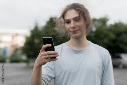 person in the online social media platform; Holding Cell Phone, with Smartphone Outdoors