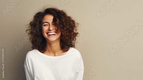 A beautiful woman wearing casual clothing, radiating joy with a bright smile in a studio setting, ideal for banners and advertisements photo