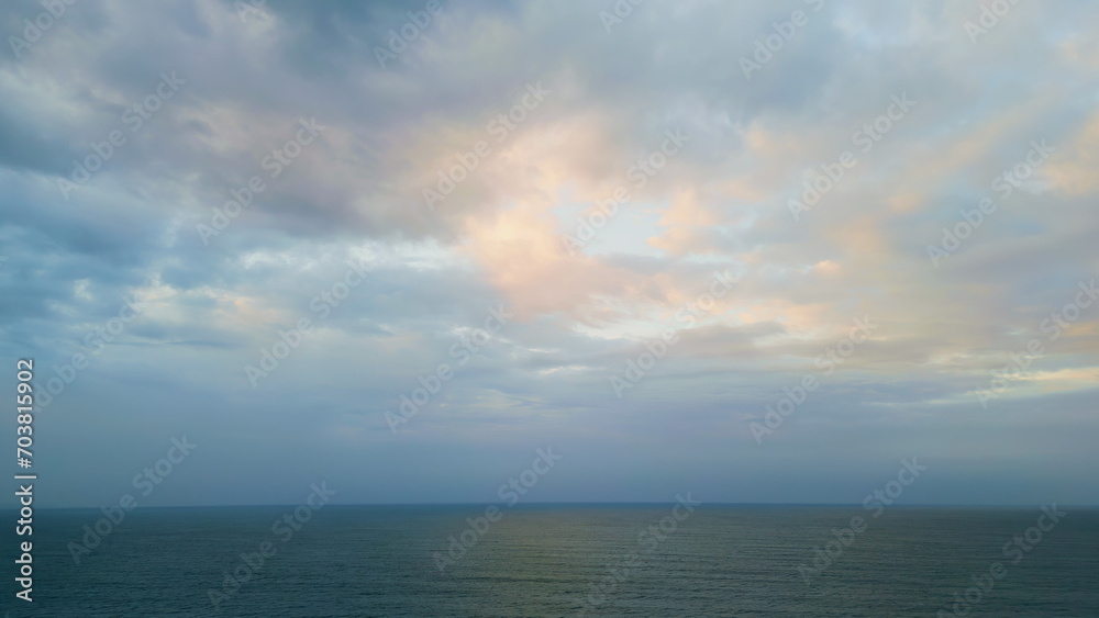 Dramatic sky dark ocean at twilight. Aerial rays breaking clouds over sea water.