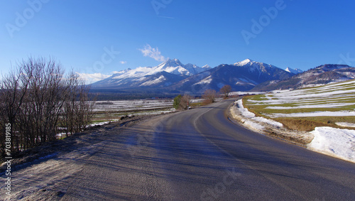 Widok na Tatry ośnieżone, droga asfaltowa, oblodzenia, trudne warunki drogowe.