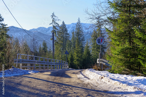 Droga górska zimą, oblodzona, most nad rzeką w Tatrach.