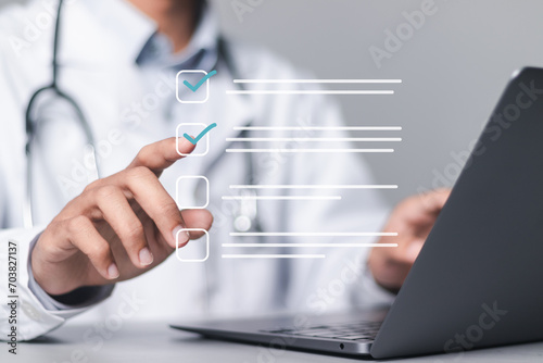 Medicine doctor use laptop to review patient medical records on virtual screens for digital healthcare. Review medical reports carefully and diagnose illnesses for an effective treatment plan. photo