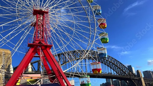 colourful Ferris wheel in Sydney amusement Theme Park with Sydney harbour Bridge in the background NSW Australia  photo