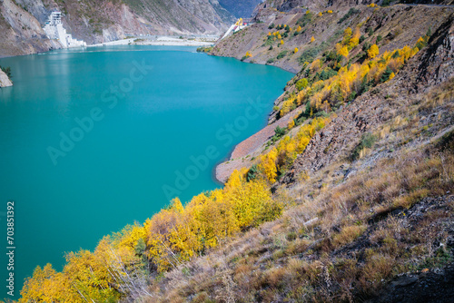Fototapeta Naklejka Na Ścianę i Meble -  Tranquil Blue Reservoir Amidst the Serene Mountain Landscape with Lush Vegetation