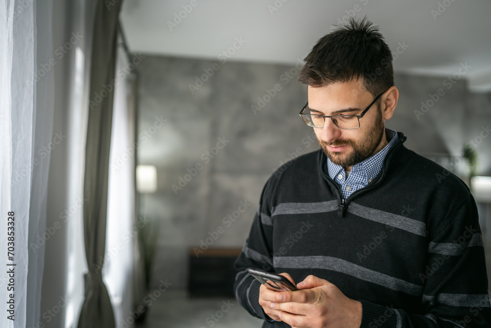 Adult man use mobile phone smartphone at home browse internet or send text messages sms texting Adult man use mobile phone smartphone at home browse internet or send text messages sms texting