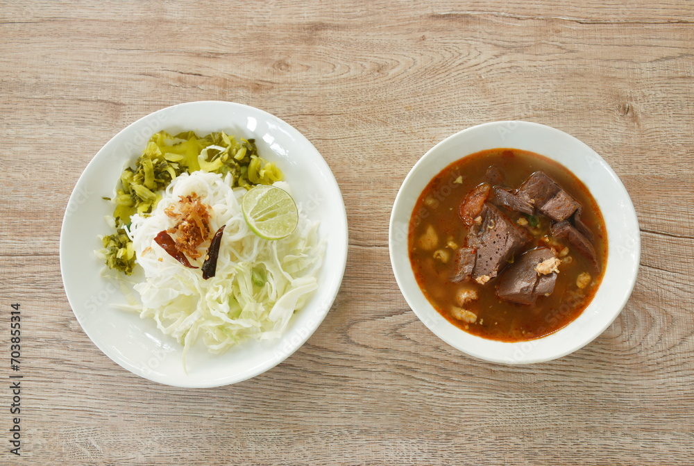 rice noodles fresh pickled and fresh cabbage eat with spicy chop pork and blood couple red cotton tree in curry sauce on plate rice noodles fresh pickled and fresh cabbage eat with spicy chop pork and blood couple red cotton tree in curry sauce on plate