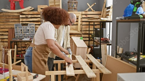 Two professional carpenters, partners in crime at woodwork, baldly measuring a sturdy wood plank in a bustling carpenter's workshop amid industry hustle photo
