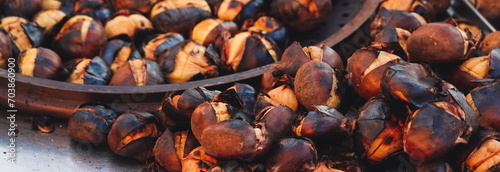 Hot chestnuts roasted on a grill with their skin on. Close-up. Turkey, Istanbul. Selective Focus. Wide Banner. Backdrop
