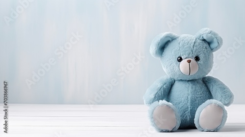 cute blue teddy toy bear on a light wall background, copy space