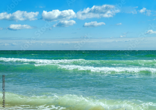 Sea waves and blue sky with white clouds.