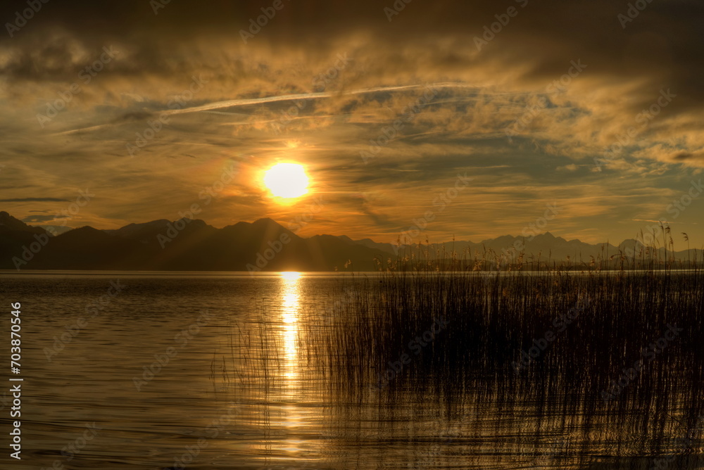 Magischer Sonnenuntergang mit Unwetterwolken an einem See