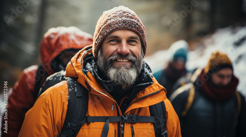 A group of elderly people are hiking together through the forest and mountains on a winter day