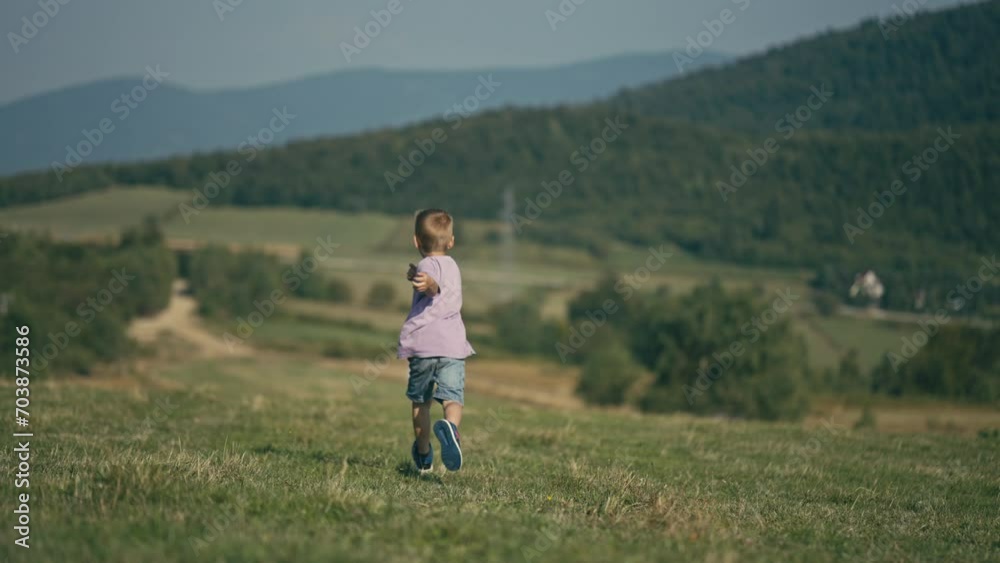 Six Year Old Caucasian Boy Running Towards His Father on a Mountain Meadow