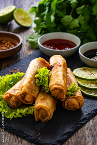 Obraz na płótnie Spring rolls and sauces on wooden table