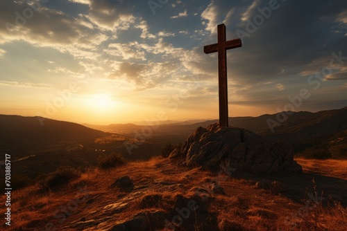 Silhouette of a cross on a hill at sunset. Easter concept
