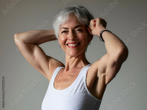 A smiling 45-year-old woman shows off her toned arms