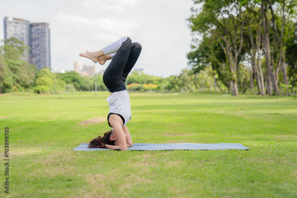 Young women have a beautiful bodies, Playing yoga in an elegant posture, in the green park, is a concept of people's recreation and health care concept. blurred background Young women have a beautiful bodies, Playing yoga in an elegant posture, in the green park, is a concept of people's recreation and health care concept. blurred background