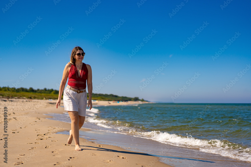 Beautiful mid adult woman walking on sunny beach
Beautiful mid adult woman walking on sunny beach