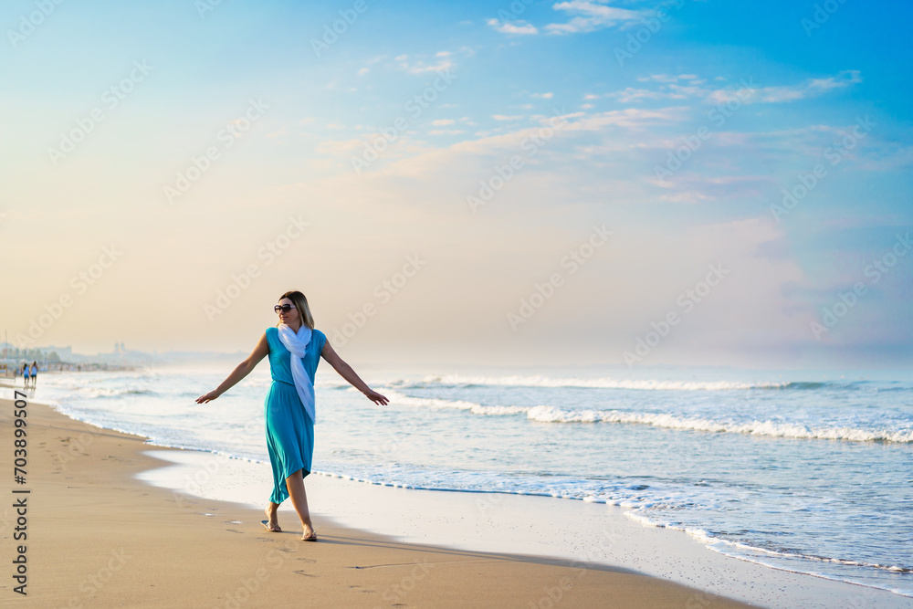 Beautiful mid adult woman walking on sunny beach Beautiful mid adult woman walking on sunny beach