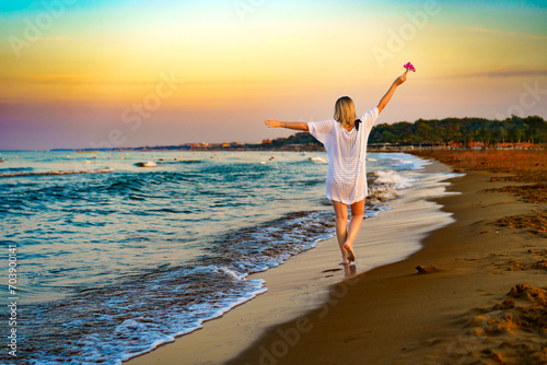 Beautiful woman walking on sunny beach photo