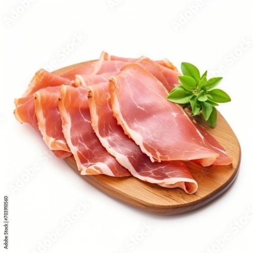 Thinly sliced prosciutto crudo with basil leaves on a wooden cutting board, photo