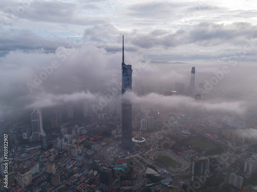 Aerial view of Kuala Lumpur city skyline under a low cloud sky