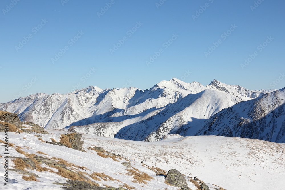 a snow-covered mountain, surrounded by breathtaking vastness, tranquility, and a sense of accomplishment.