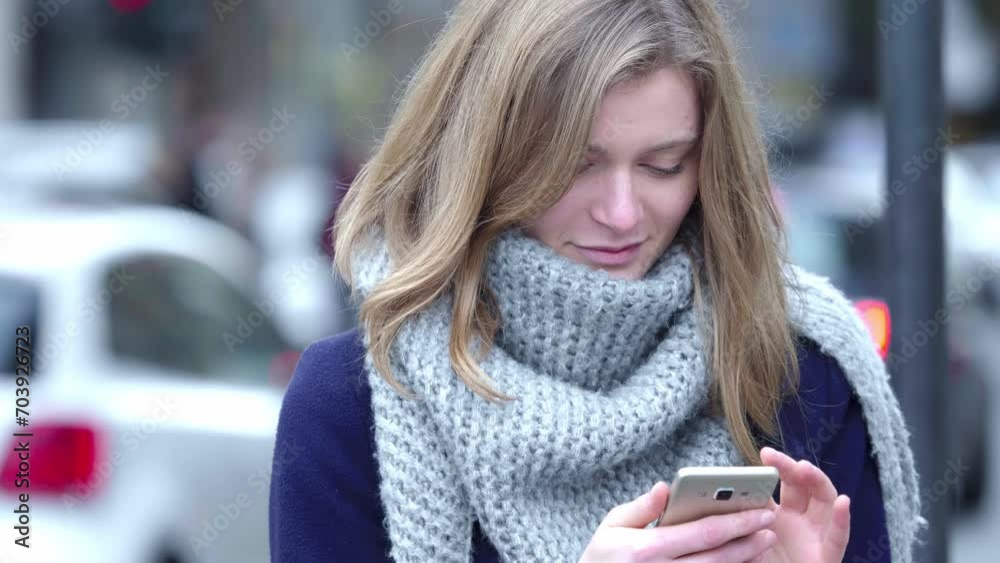 A radiant young blonde woman smiles while texting a close friend about an upcoming reunion, spreading joy through her message