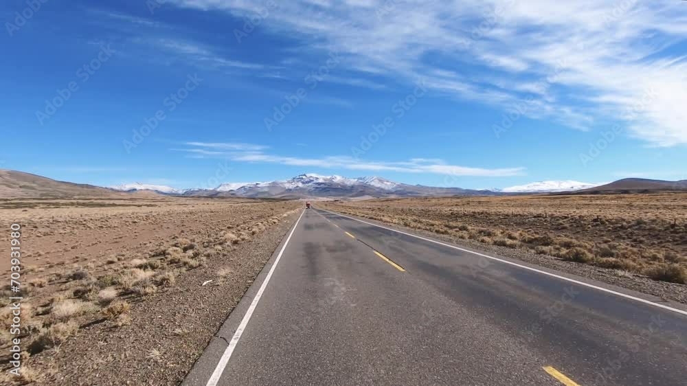Point of view of a car driving along the road in the yellow field. View of the mountains with snowy peaks in the horizon.
Point of view of a car driving along the road in the yellow field. View of the mountains with snowy peaks in the horizon.