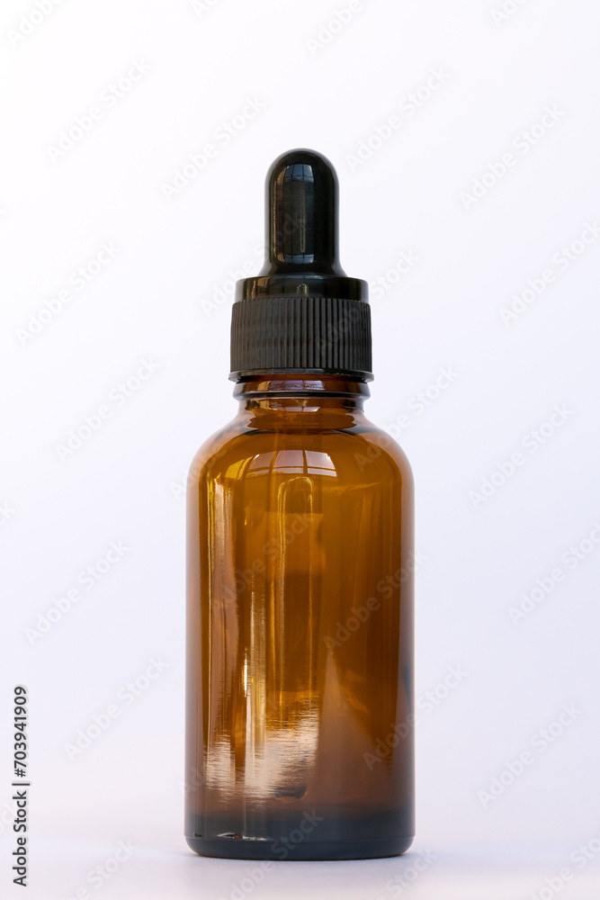 Amber glass cosmetics bottle with dropper, white background. Natural skin care SPA beauty product product design.