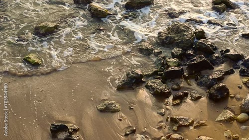 Sea waves lapping below with a lot of foam. stones and rocks in water.