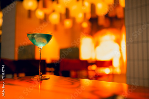 One delicious ice cold cocktail in exquisite glasses stand on a wooden table in a restaurant photo