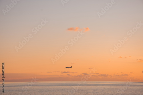 The plane is landing. Sunset on the sea coast.