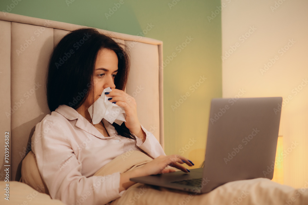 Sick woman working from home on bed Sick woman working from home on bed