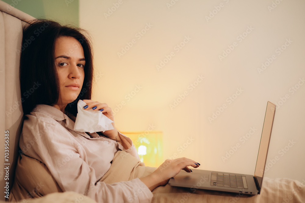 Sick woman working from home on bed
