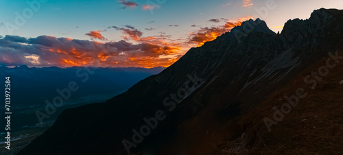 High resolution stitched alpine sunset or sundowner summer panorama at the famous Nordkette mountains near Innsbruck, Tyrol, Austria photo