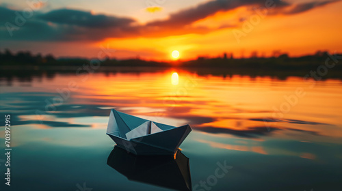 Paper boat on a calm lake at sunset