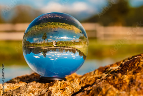 Crystal ball alpine summer landscape shot with reflections in a pond at the famous Maria Waldrast monastery, Matrei am Brenner, Innsbruck, Tyrol, Austria