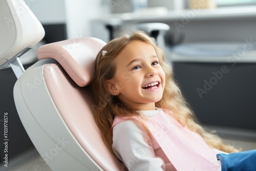 smiling little girl sitting in dental chair and looking at camera at clinic   little girl during the examination  creating a sense of trust and comfort in the dental clinic