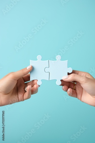 Two hands holding puzzle pieces to complete the puzzle,