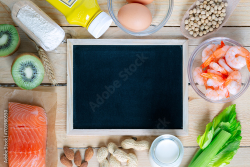 Composition with common food allergens including egg, milk, soya, peanuts, kiwi, fish, seafood, wheat flour, mustard, celery with blackboard for copyspace photo