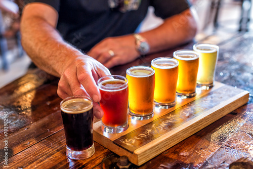 Mans hands reach in to try a flight of beers in a brewery