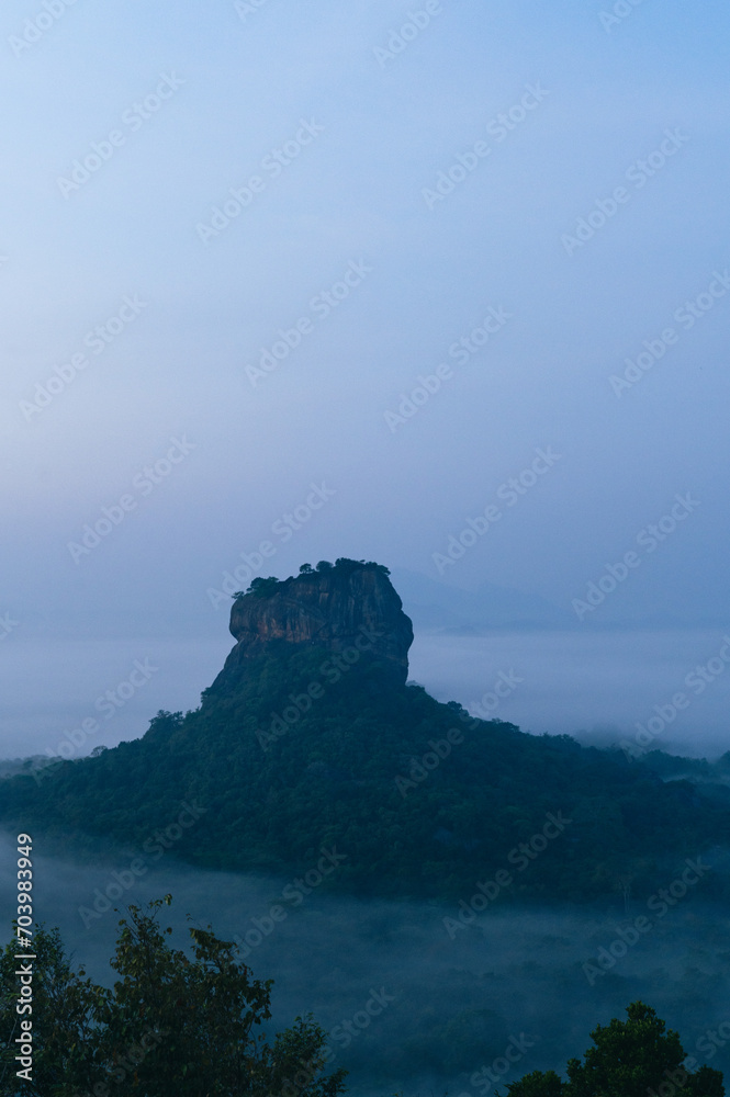 View of Sigiriya Rock from Pidurangala Rock at Sunrise on a Foggy Morning 