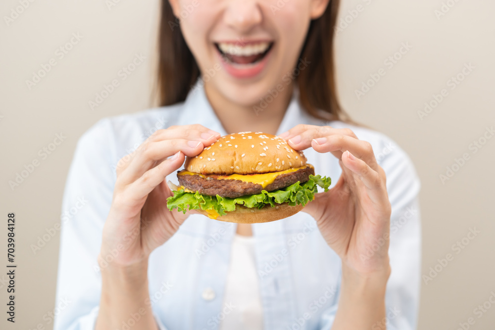 Fast Food concept, happy delicious asian young woman eating tasty burger or hamburger with cheeseburger, girl hungry holding junk food with meat and vegetable in brunch, lunch. Unhealthy snack meal. Fast Food concept, happy delicious asian young woman eating tasty burger or hamburger with cheeseburger, girl hungry holding junk food with meat and vegetable in brunch, lunch. Unhealthy snack meal.